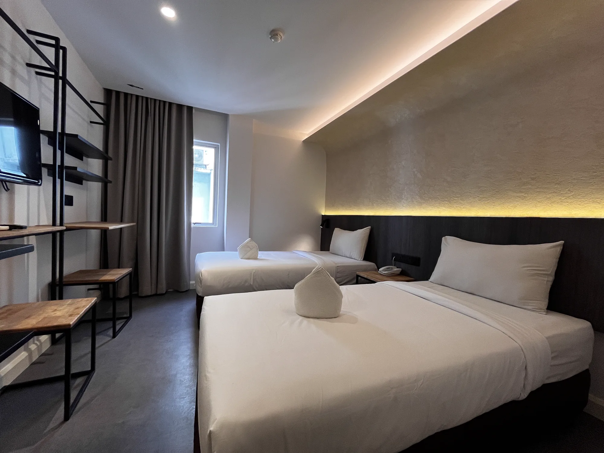 MyHotel guest room with twin beds, workspace and concealed lighting